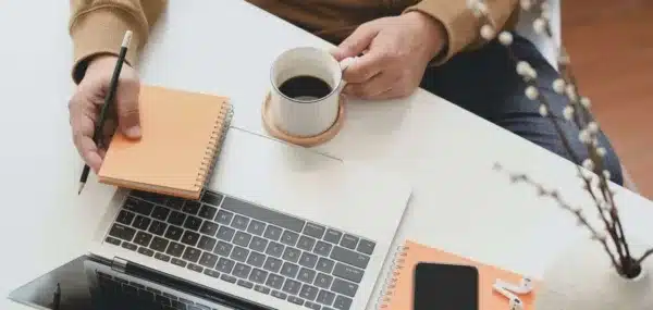 Small business owner planning at their laptop with a coffee
