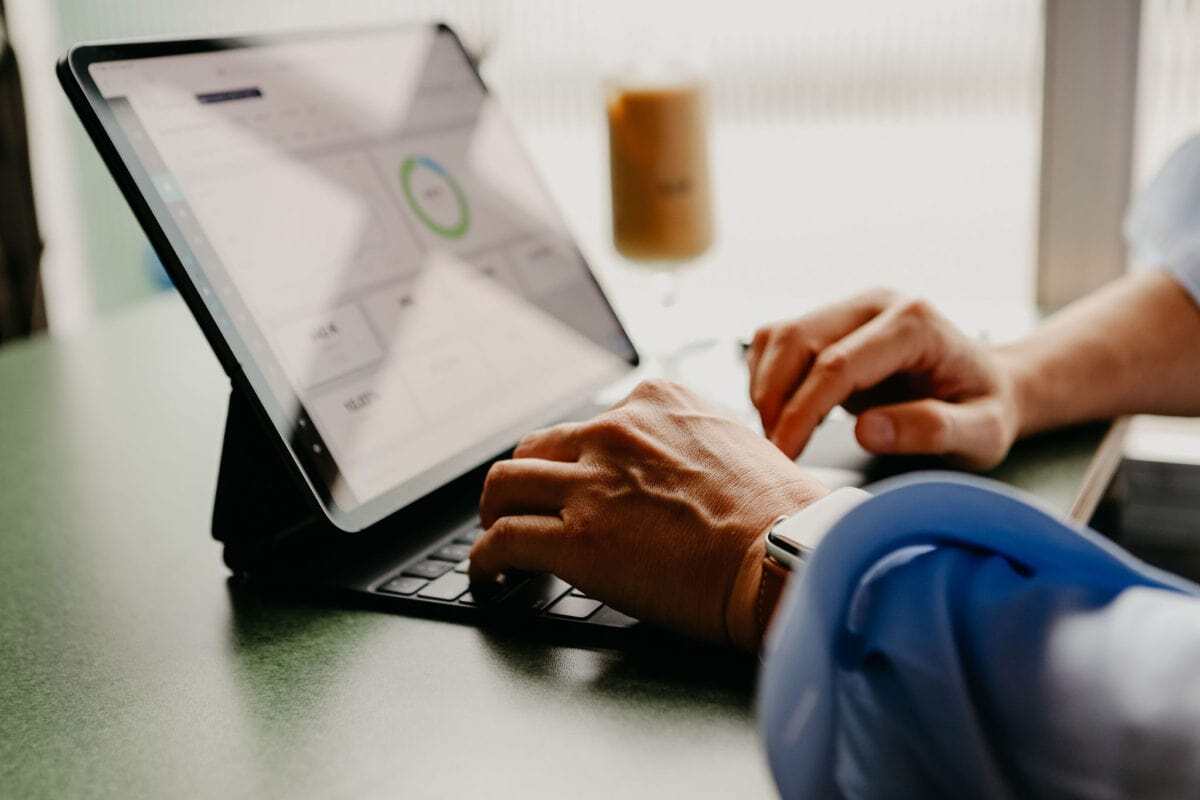 Closeup of hands working on a digital marketing report on an iPad
