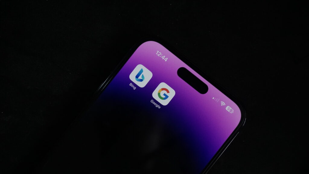 cell phone with search icons for Bing and Google